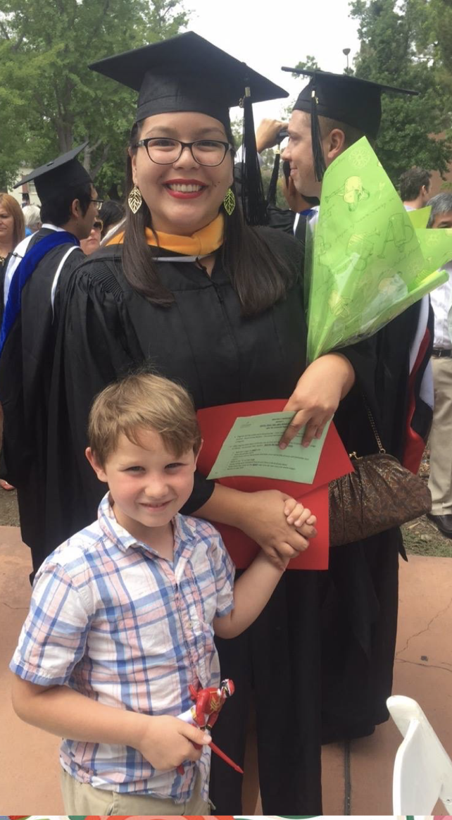 Jessica Orozco wearing cap and gown standing with her nephew James Kitchens